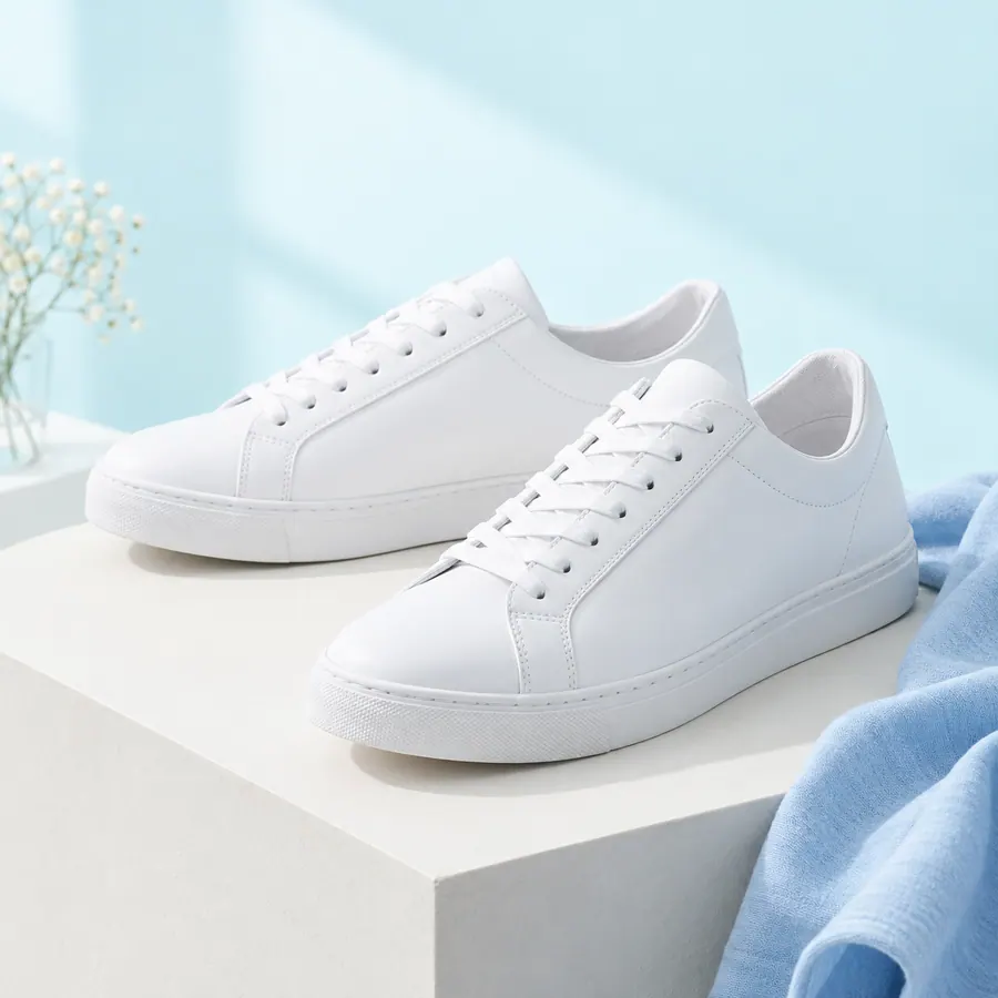 Freshly cleaned white sneakers on a light aqua background